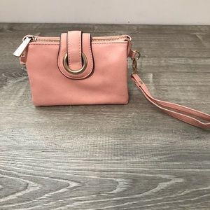 Pink wristlet with shoulder strap.